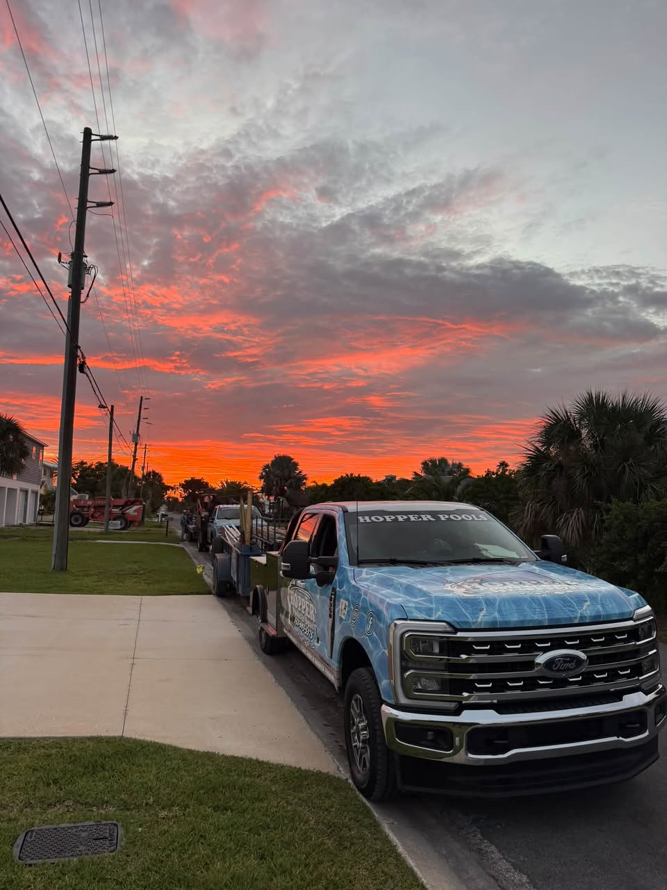 Hopper Pools work truck at a Florida sunset