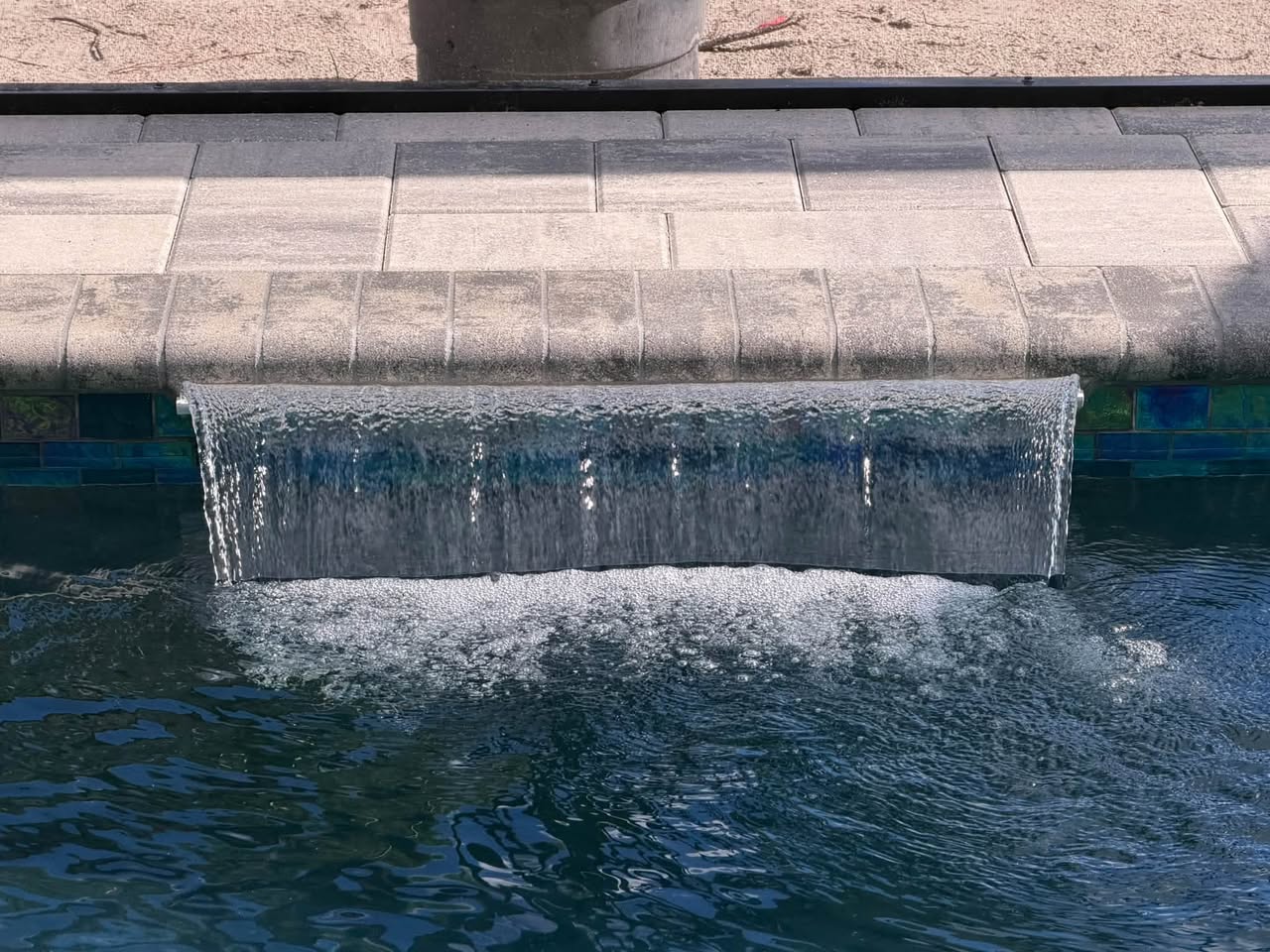 Sheet waterfall flowing into a completed pool